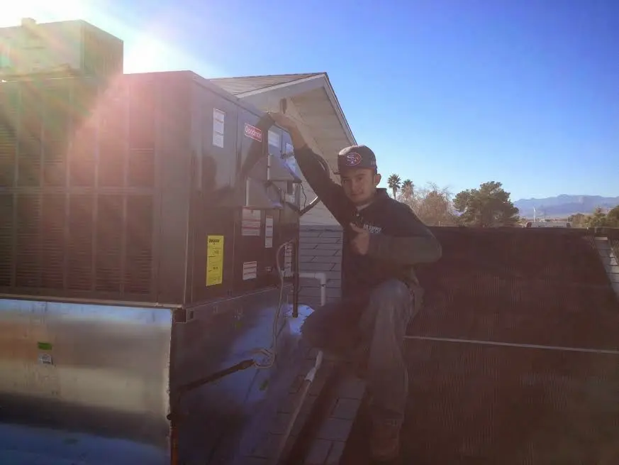 HVAC technician performing AC Tune-Up on a rooftop unit in Wellston